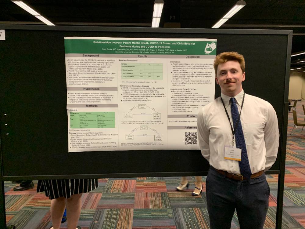 A photo of Evan Daldin presenting a research poster.