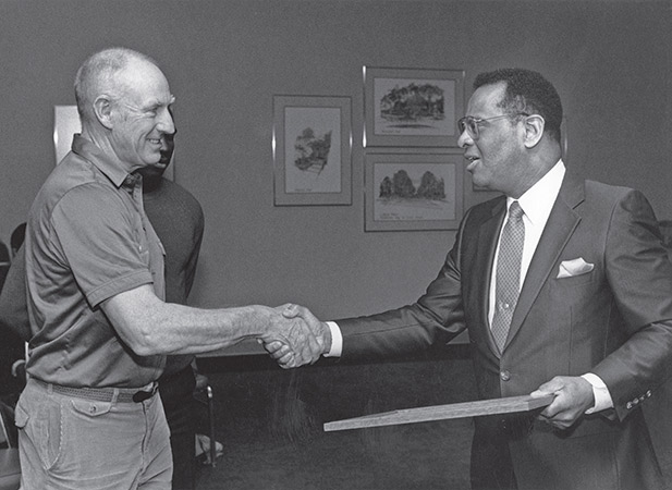 April 27, 1 988: President Porter presents an award to Coach Bob Parks for his men's track team having won the MAC indoor invitational meet.