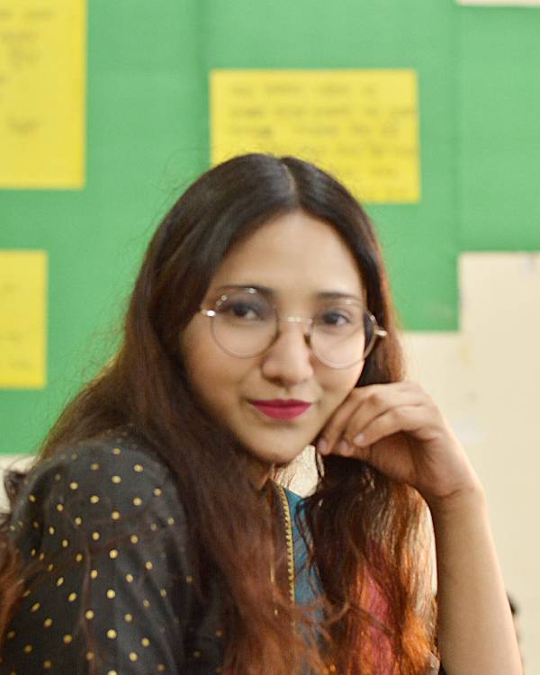 Smiling person with glasses indoors