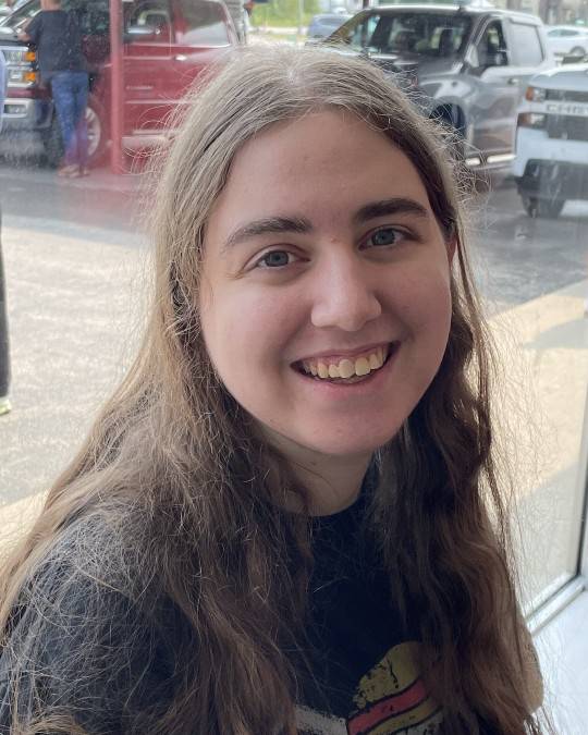 Smiling person in front of window