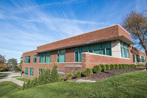 An image of the outside of Rackham - a brick building with green tinted windows.