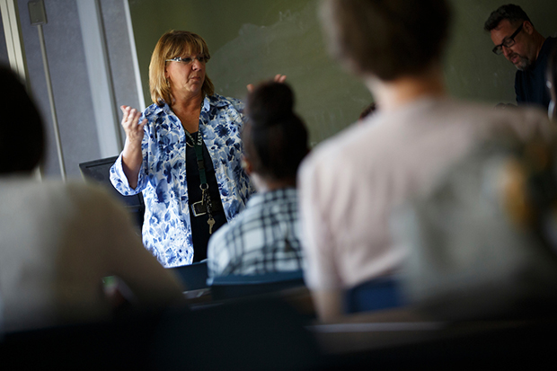 A female professor teaches a class of students.