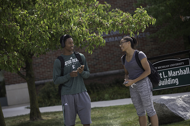 A male and female student talk outside of Marshall Building.