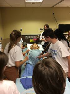 A photograph of students with medical dummies