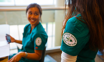 Two eastern nursing students wearing green scrubs