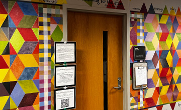 A picture of the door to the Early Childhood Lending Library with a mural of multicolored diamond shapes on either side of it 