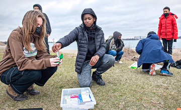 A photo of a group of students practicing water quality testing at Belle Isle in Detroit.