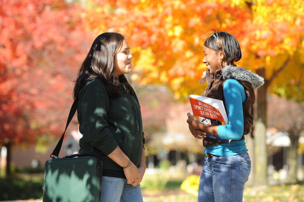 Two female students speaking on campus