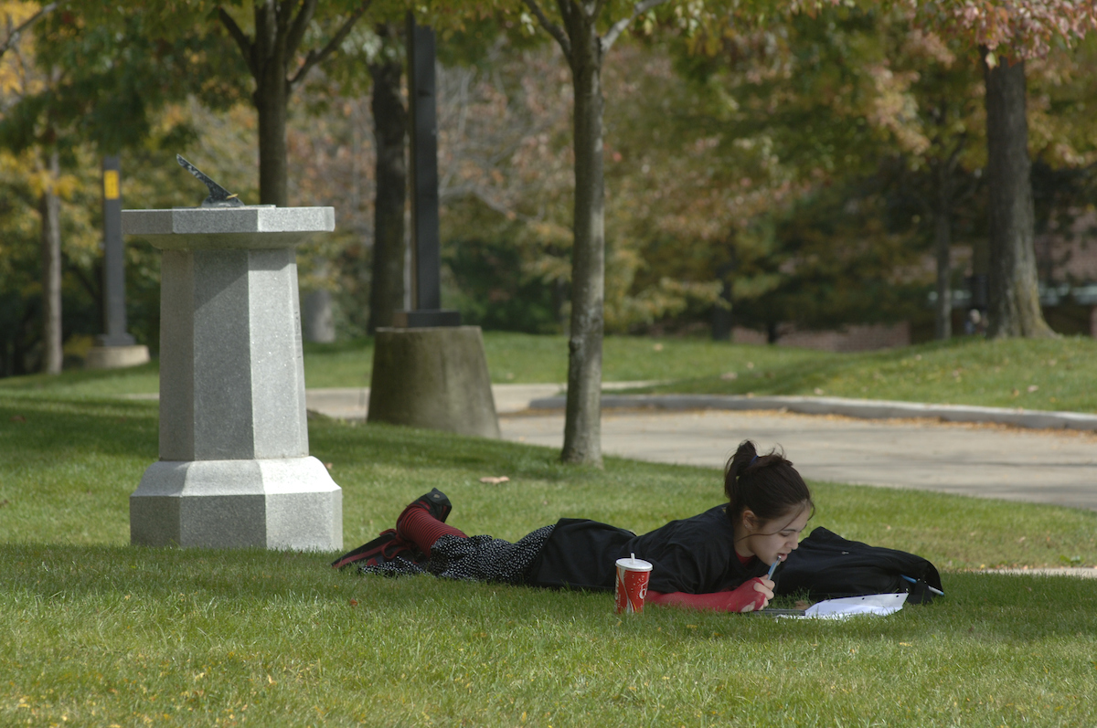 A female student reading on campus