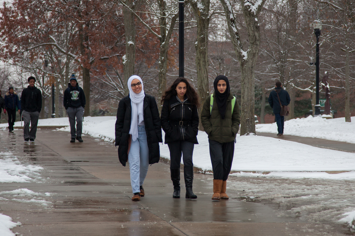 Three female students walking on campus