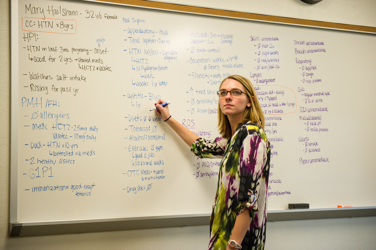An instructor writing on a white board