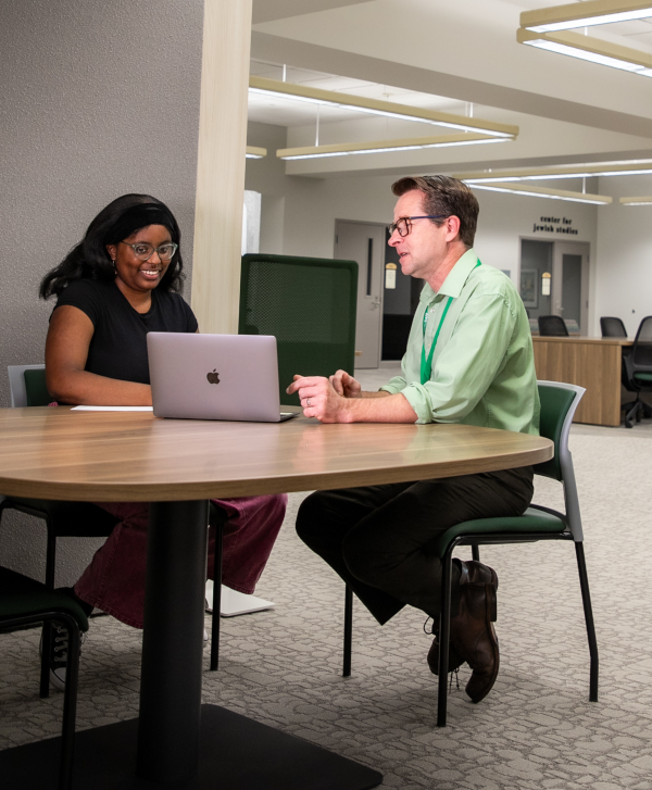 student and librarian talking at a table